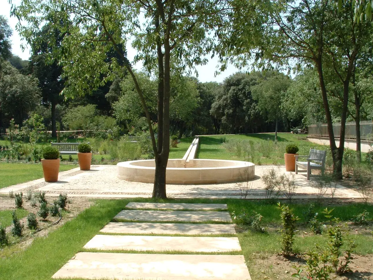 Le parc de l'arbousi&egrave;re, avec sa fontaine circulaire et ses all&eacute;es de dalles, invite &agrave; la promenade paisible sous les arbres.