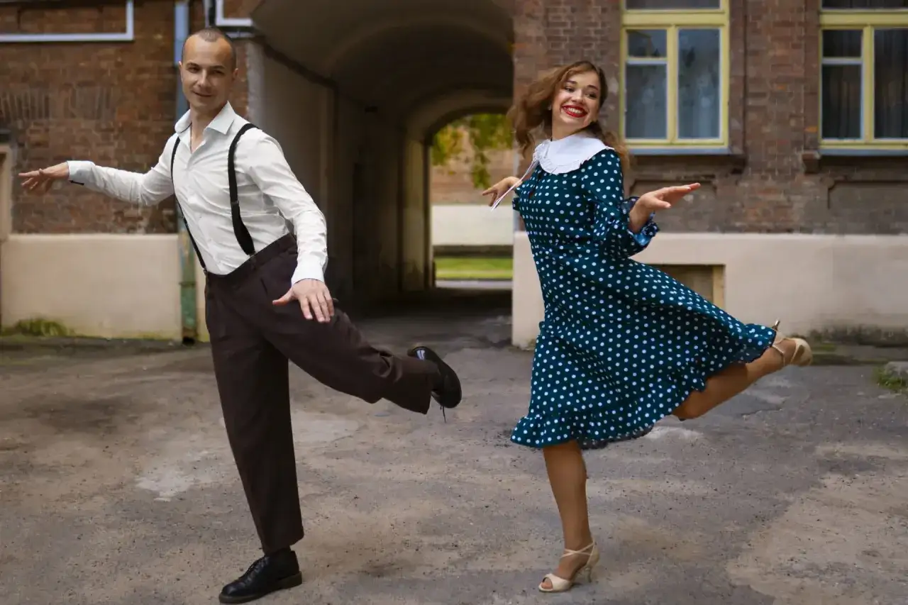 Para tańczy swinga, on w białej koszuli i szelkach, ona w grochy. Wspaniała partnerka do tańca!