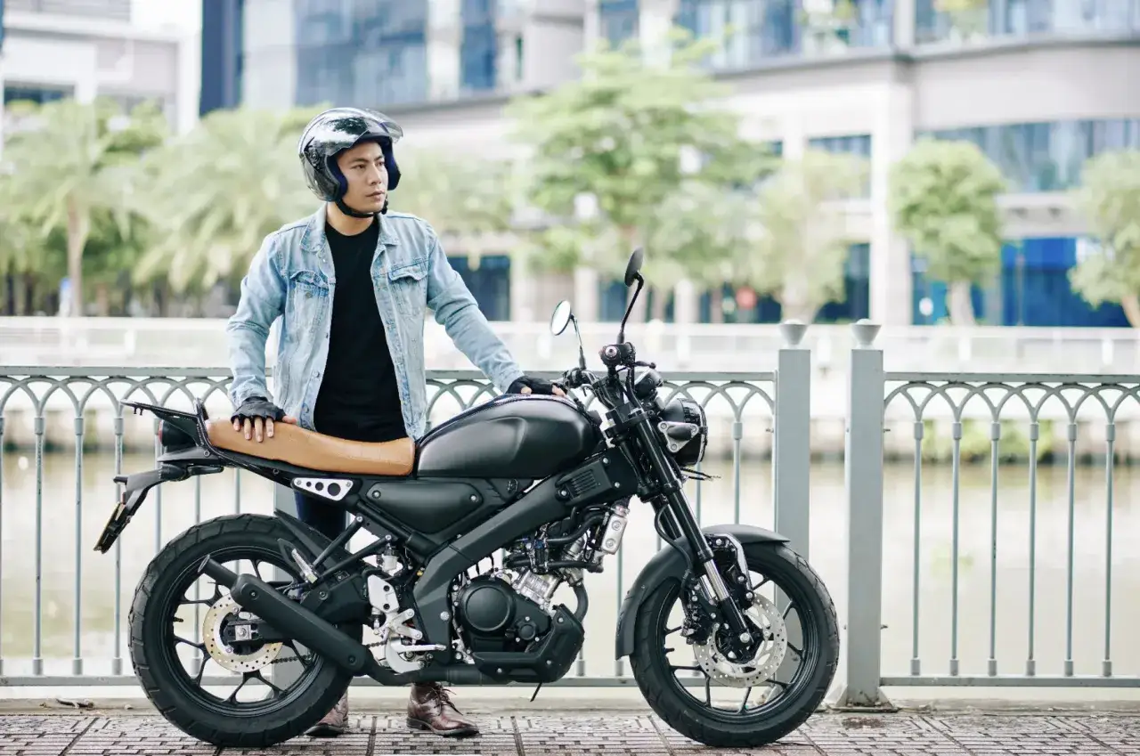 kierowca opierający się o swój motocykl