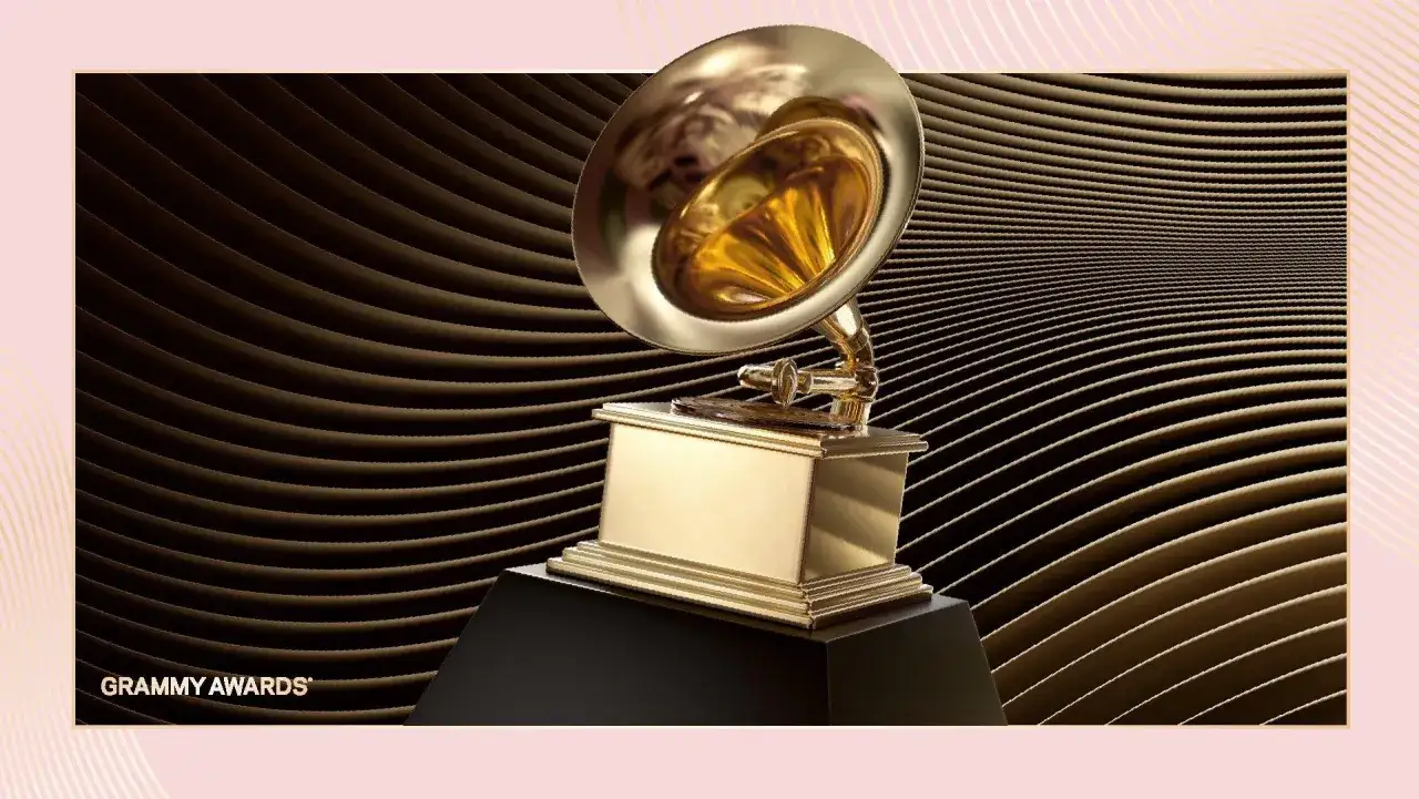 Złoty gramofon, symbol nagrody Grammy za najlepszy teledysk, lśni na tle falujących, brązowych linii.