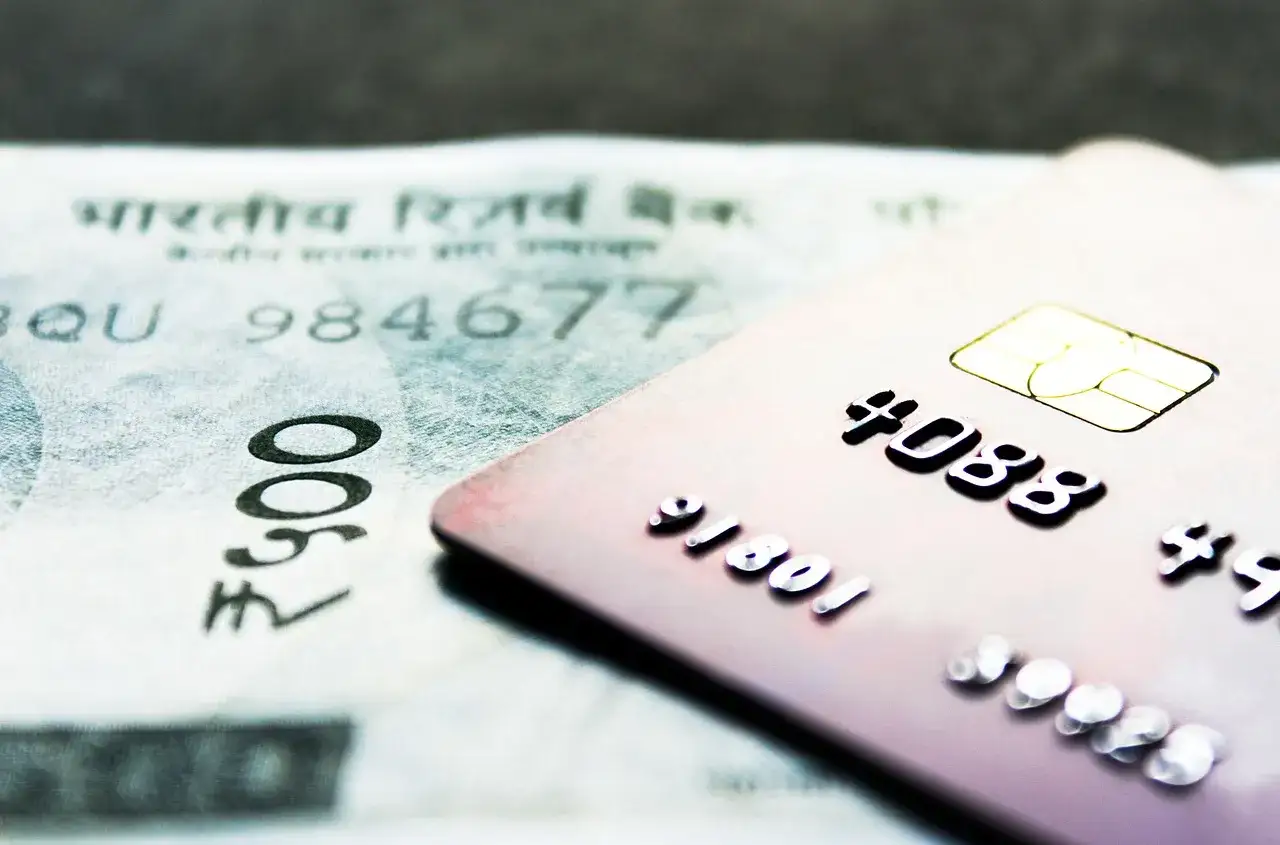 Karta płatnicza na tle banknotu. Zastanawiasz się, czy warto sprzedawać mieszkanie?