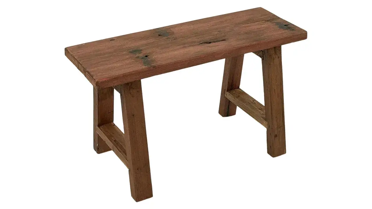 En rustik b&auml;nk i m&ouml;rkt tr&auml; med synliga &aring;dringar och en sliten yta. Perfekt f&ouml;r en lantlig inredning.