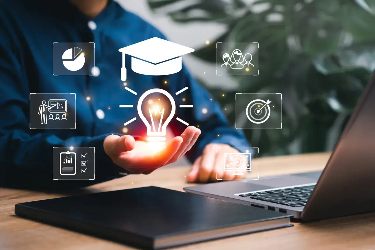 Eine Hand hält eine leuchtende Glühbirne, umgeben von Symbolen für Bildung und Erfolg. Digitale Tools unterstützen den Lernprozess.