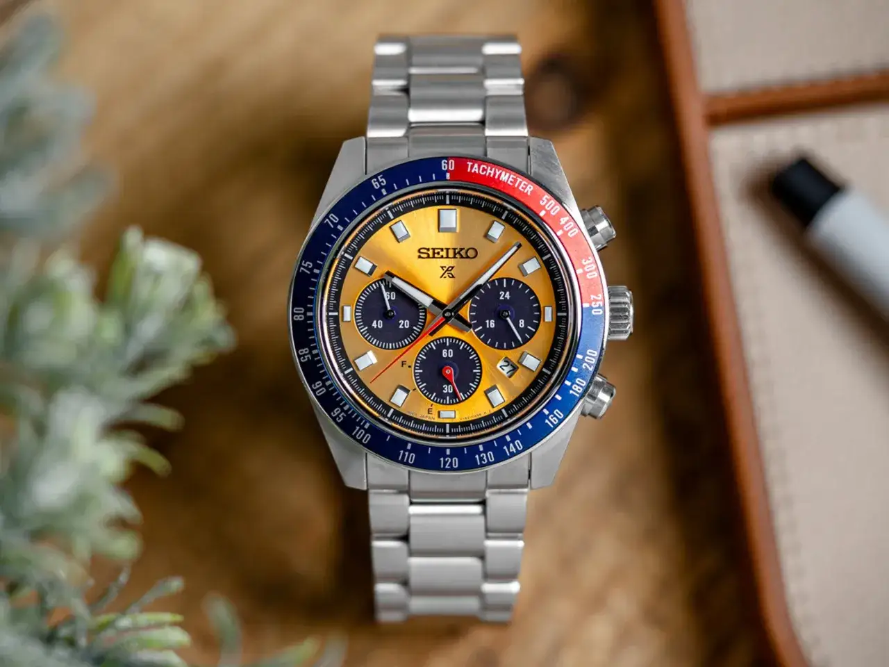 Stylowy zegarek Seiko z ż&oacute;łtą tarczą i niebieskim pierścieniem tachymetru. Jego mechanizm solarny zapewnia niezawodność.