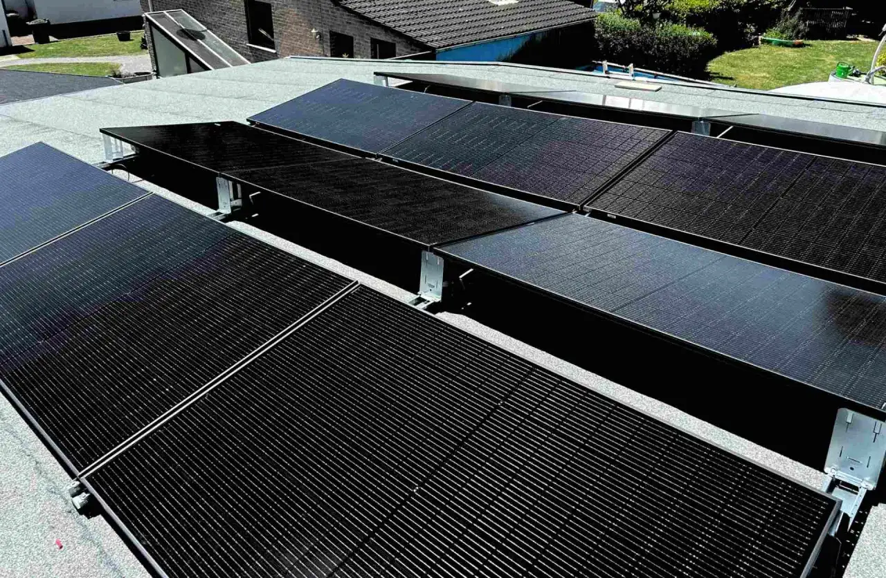 Solarmodule auf einem Bitumen-Flachdach, sicher befestigt f&uuml;r optimale Photovoltaik-Leistung.