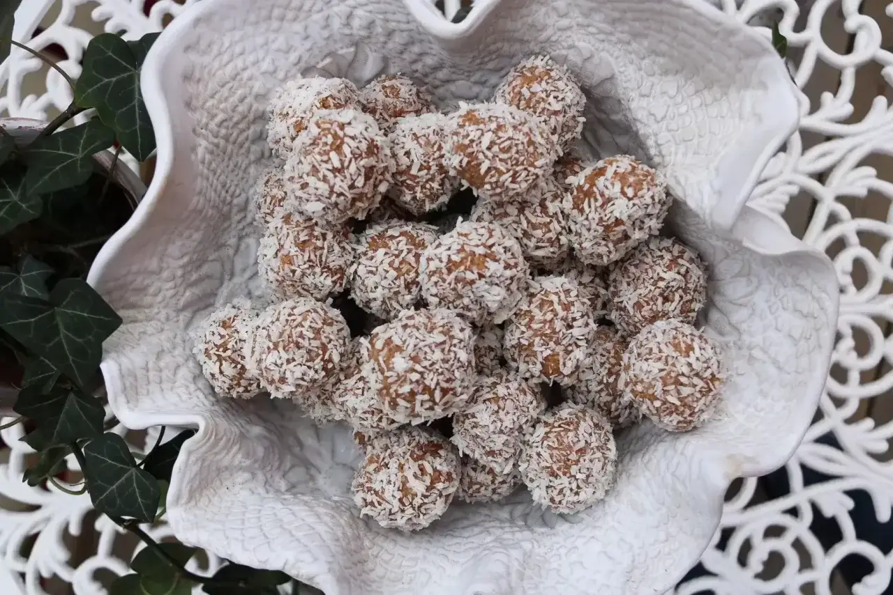 En skål med hemgjorda havrebollar, rullade i kokosflingor. Perfekt för ett enkelt havrebollar recept.