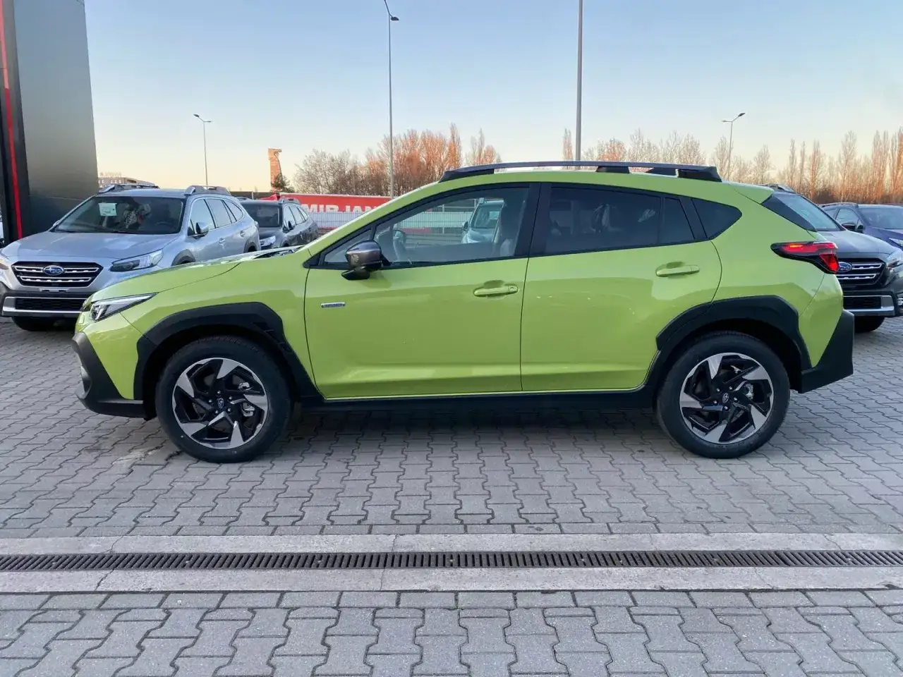 Jasnozielone Subaru na placu dealerskim, idealne do subaru leasing. Obok inne modele marki.
