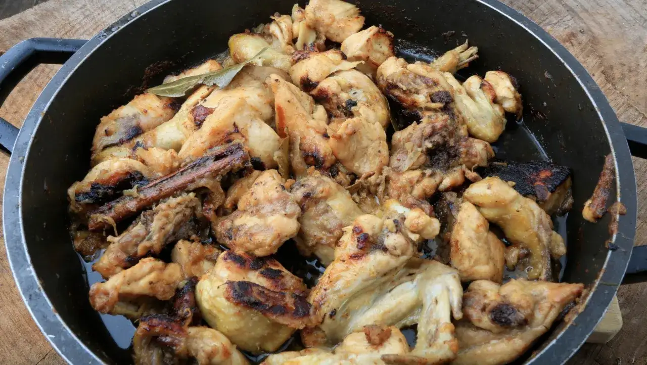 Sabroso pollo al ajillo estilo Arguiñano, dorado y jugoso en sartén, listo para disfrutar.