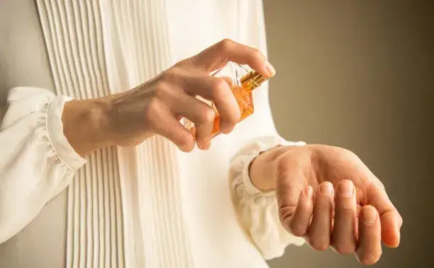 frau trägt festes parfum auf handgelenk auf nahaufnahme