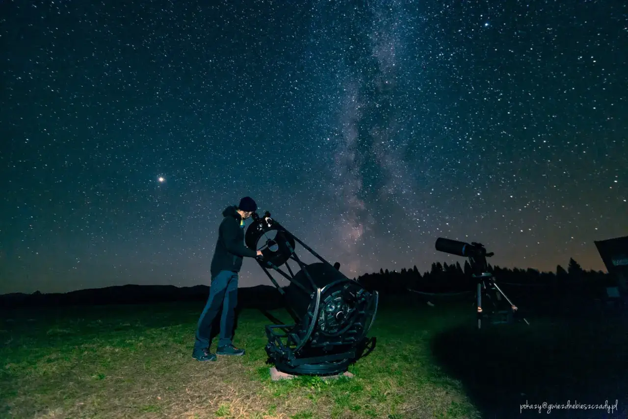 Nocne niebo pełne gwiazd, człowiek przy teleskopie. Idealne miejsce do obserwacji astronomicznych.