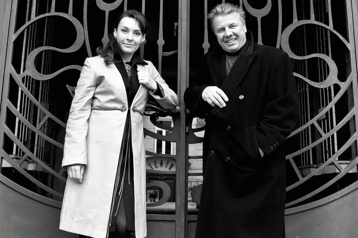 Para, która stoi przed bramą teatru. Kobieta w jasnym płaszczu, mężczyzna w ciemnym. Nie wiadomo, ile lat ma Justyna Sieńczyłło.