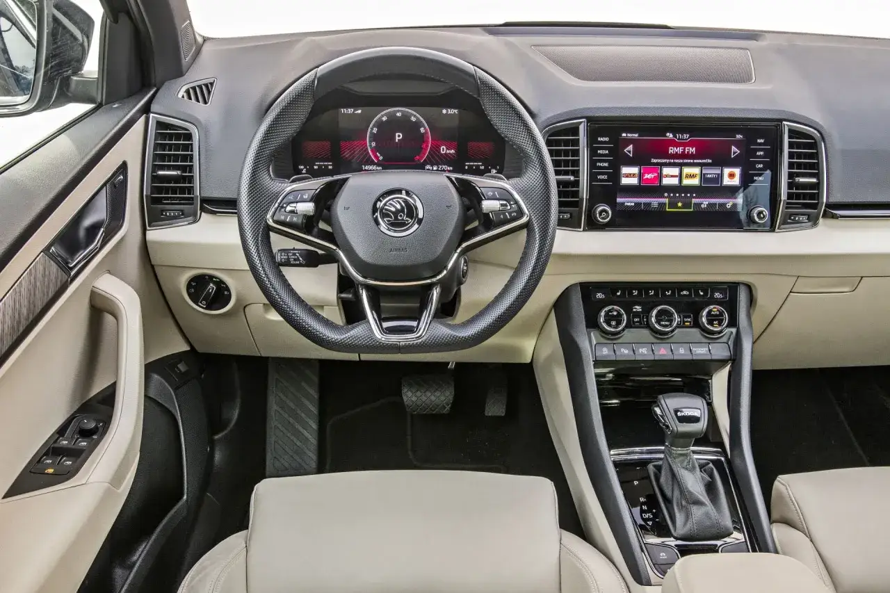Wnętrze Škody Karoq z cyfrowymi zegarami i ekranem multimedialnym. Sprawdź aktualną skoda karoq cena i wyposażenie.