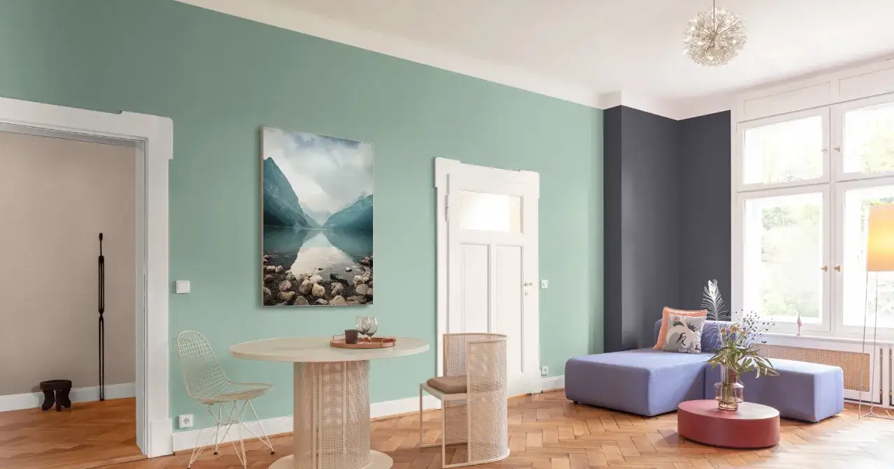 Nowoczesny salon z kanapą, stolikiem i krzesłami. Ściany pomalowane farbą lateksową matową w odcieniach zieleni i grafitu.