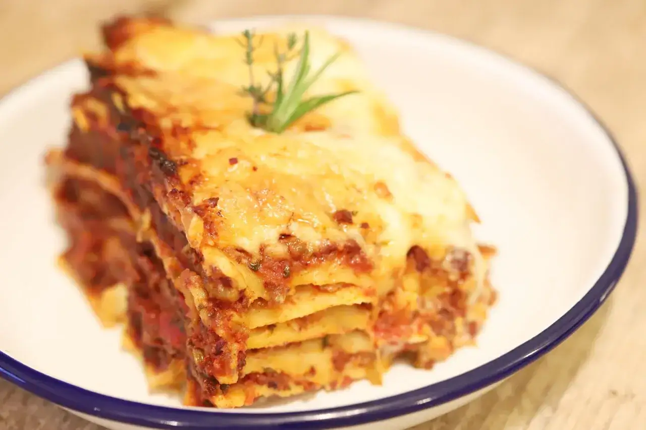 Ein Stück Lasagne mit geschmolzenem Käse und Kräutern, perfekt für ein köstliches lasagne rezept.