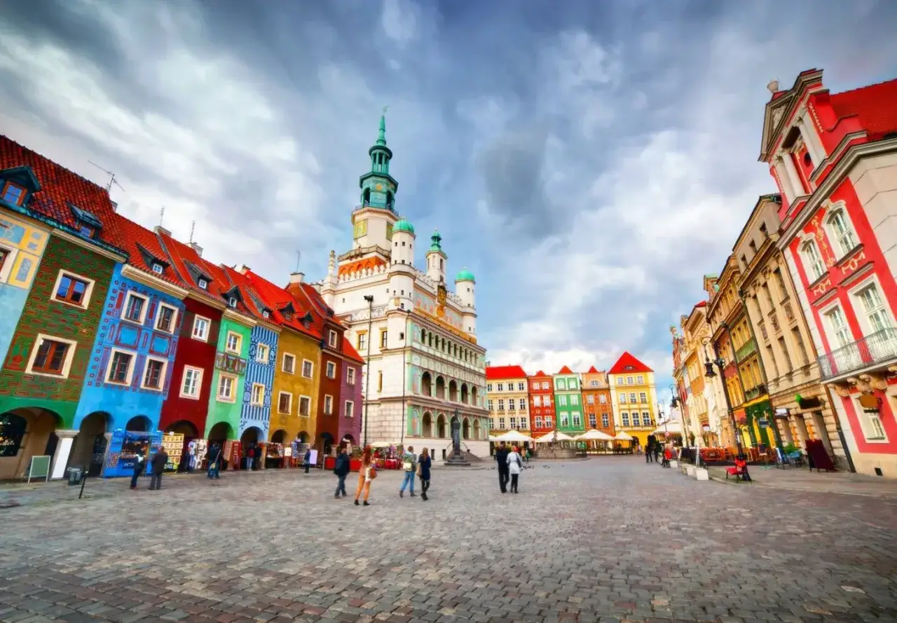 Kolorowy Rynek w Poznaniu, z Ratuszem w tle, to jedna z głównych poznańskich atrakcji. Tętni życiem, przyciągając turystów.