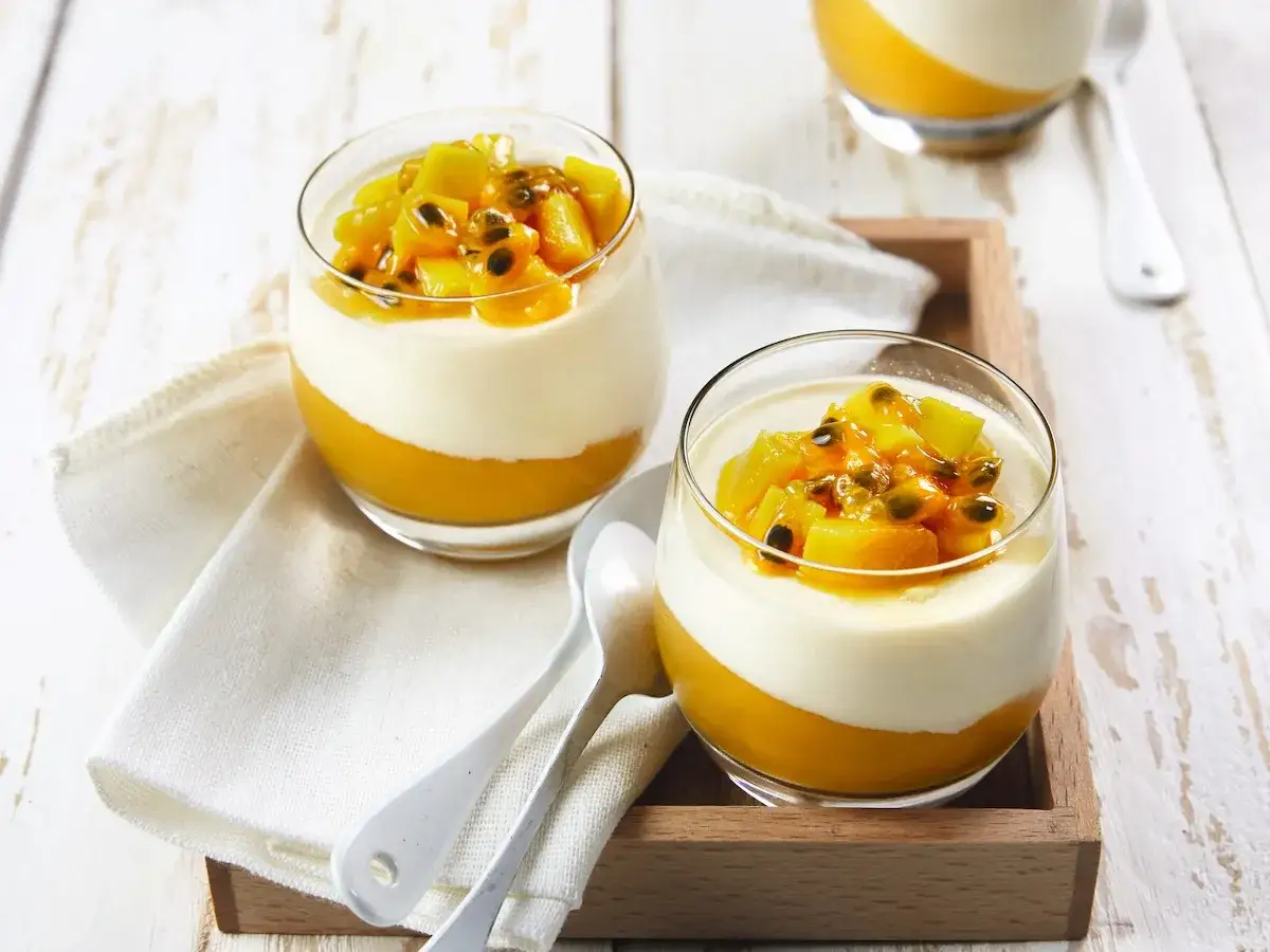 Deux verrines de panna cotta fruit de la passion, un dessert crémeux et fruité, prêt à être dégusté.