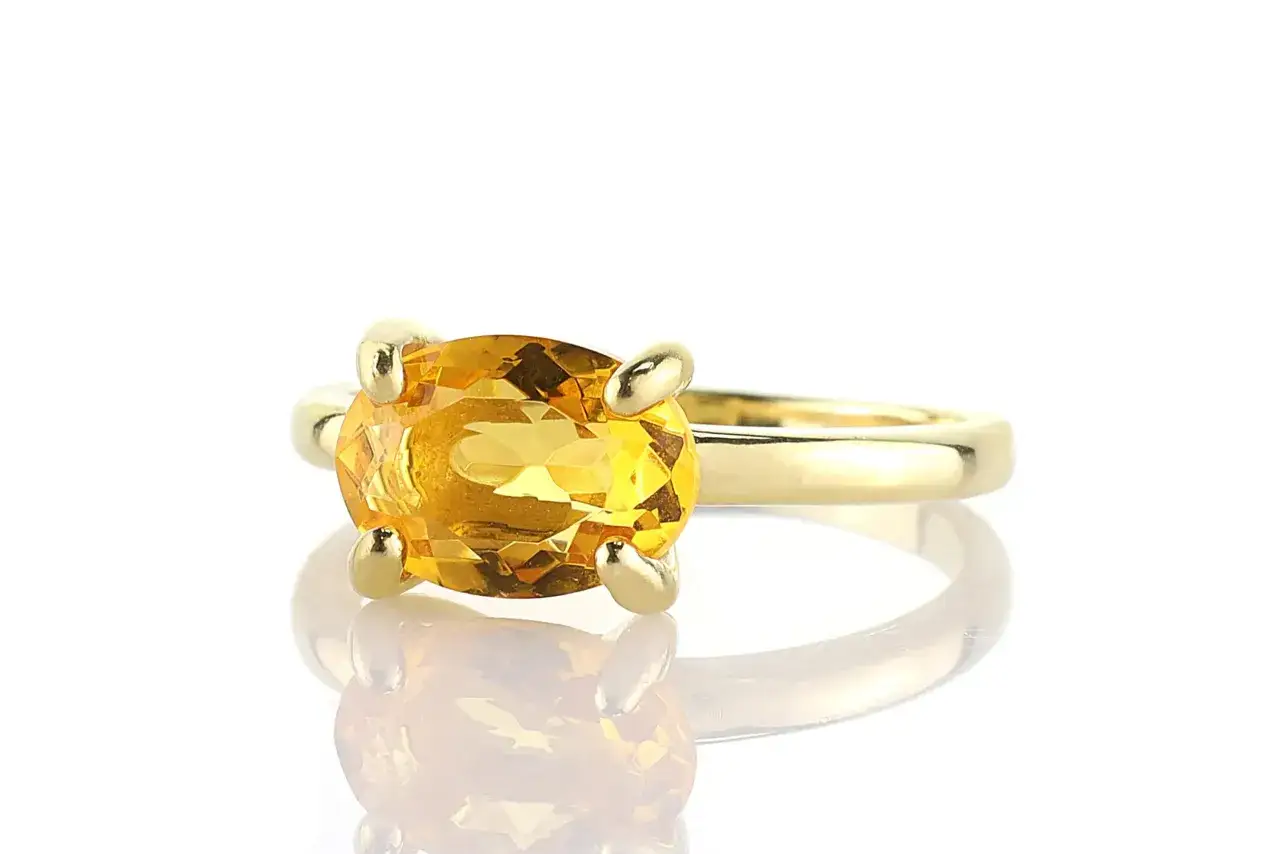 Anello d'oro con un grande quarzo giallo sfaccettato, che cattura la luce come un raggio di sole.
