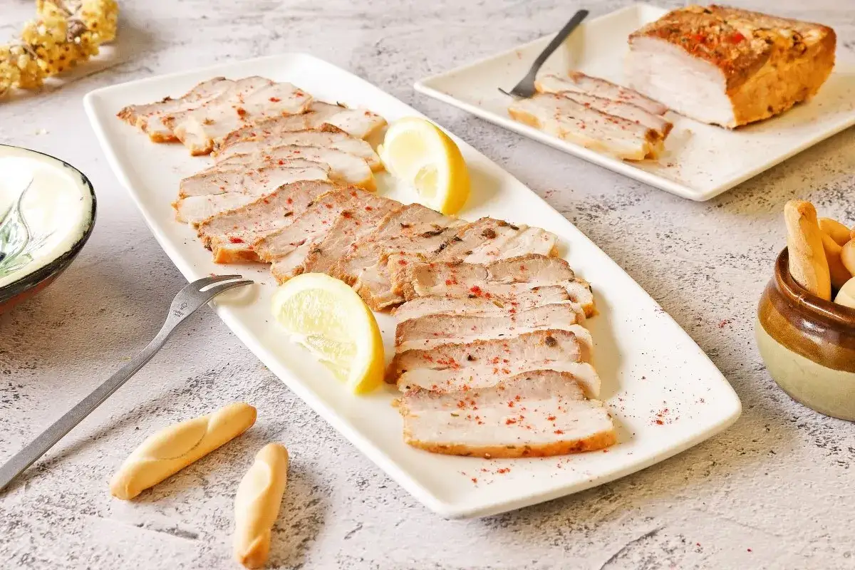 Chicharrón de Cádiz en lonchas, servido con limón y picos. Un plato que evoca el sabor de la costa gaditana.