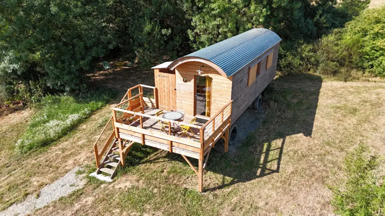 Charmante roulotte en bois pour un camping à la ferme dans les Vosges, avec terrasse et vue sur la nature.