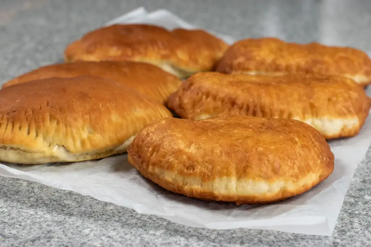 Gyllene piroger på bakplåtspapper, redo att fyllas med ditt favoritrecept. Perfekt för fika!
