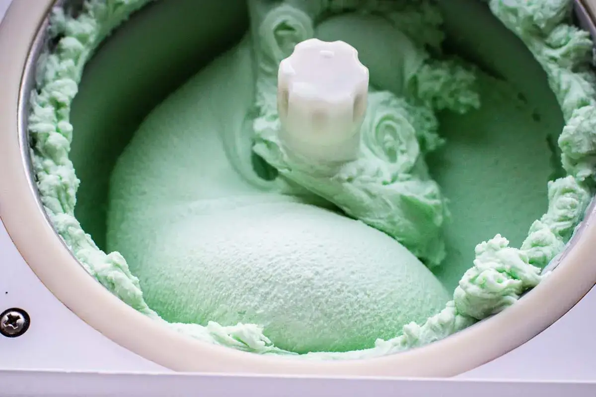 Gelato alla menta fresco e cremoso, appena fatto nella gelatiera, con la sua texture invitante e il colore verde brillante.