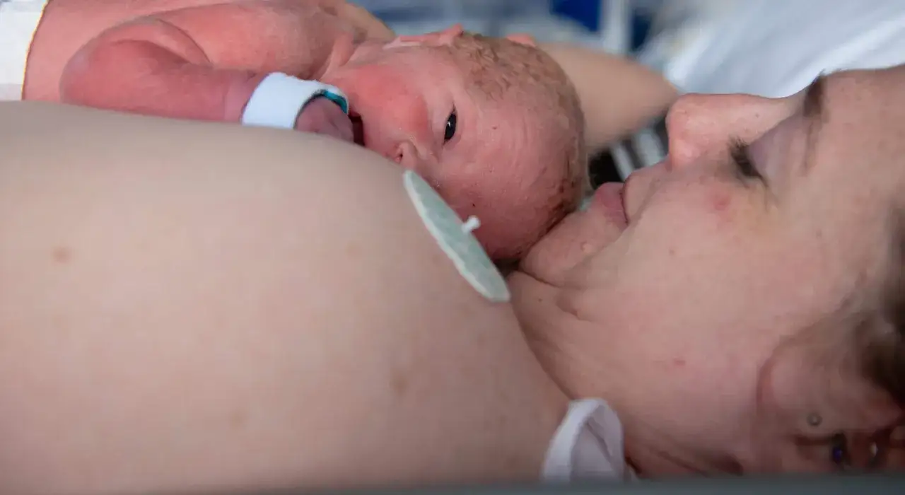 Neugeborenes Baby auf der Brust der Mutter. Vielleicht schreit es, weil es die neue Welt erkundet.