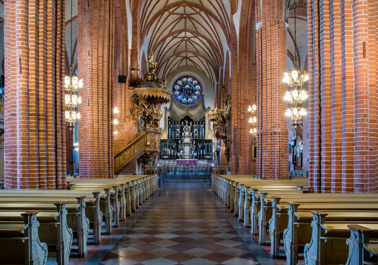 Interi&ouml;r av Storkyrkan i Gamla Stan, Stockholm. L&aring;nga b&auml;nkrader leder mot altaret under ett valv.