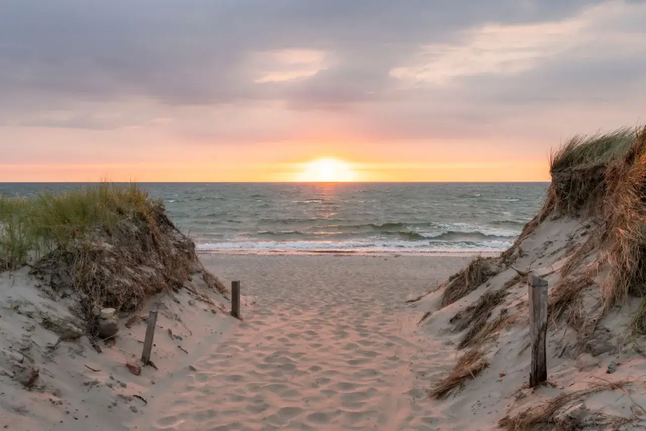Sonnenuntergang an der polnischen Ostsee. Ein Pfad durch D&uuml;nen f&uuml;hrt zum Meer. Ein echter Geheimtipp f&uuml;r Ruhesuchende.