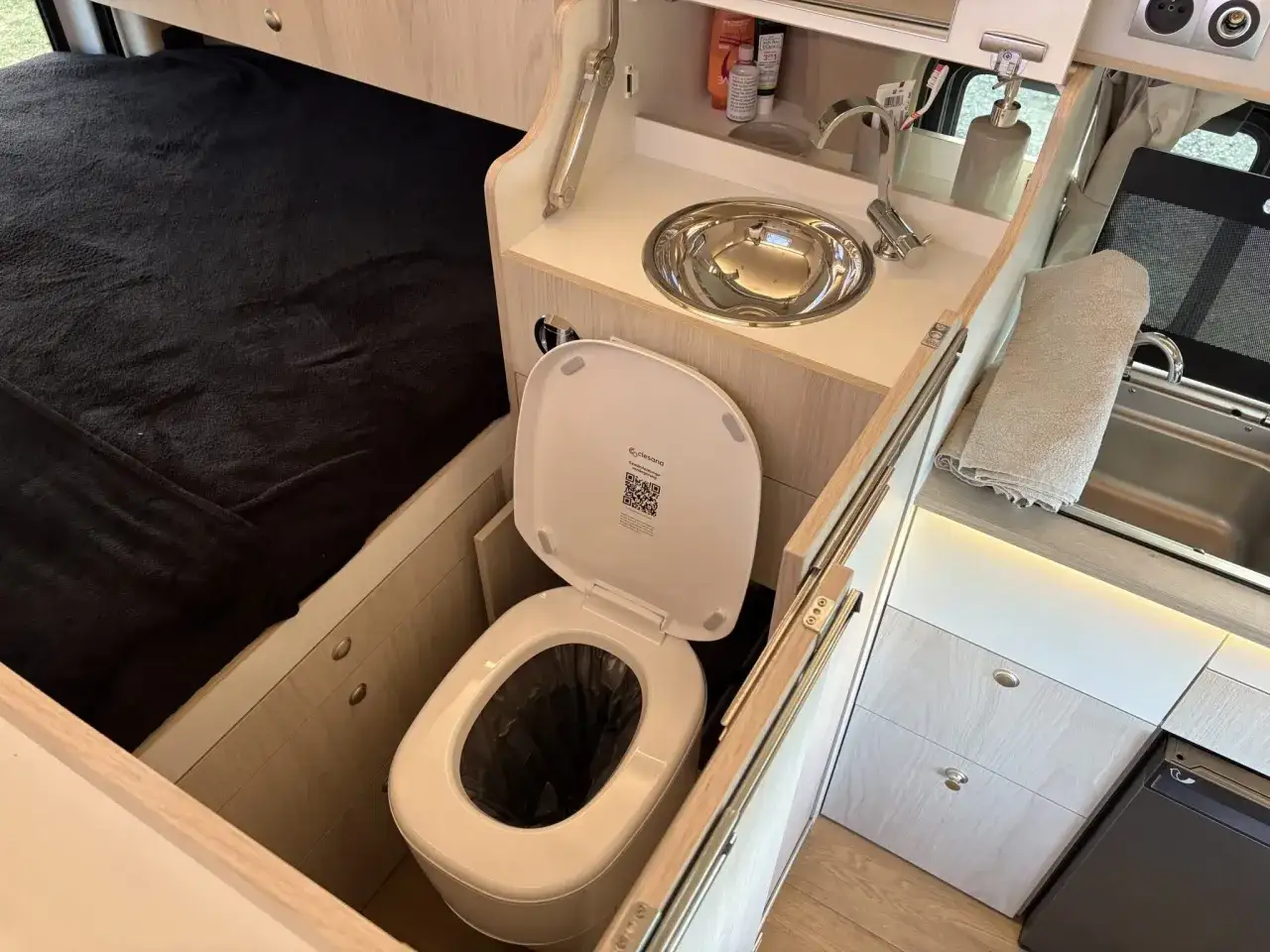 Am&eacute;nagement int&eacute;rieur d'un van avec un lit, un &eacute;vier et un van avec toilette int&eacute;gr&eacute;e, pr&ecirc;t pour l'aventure.