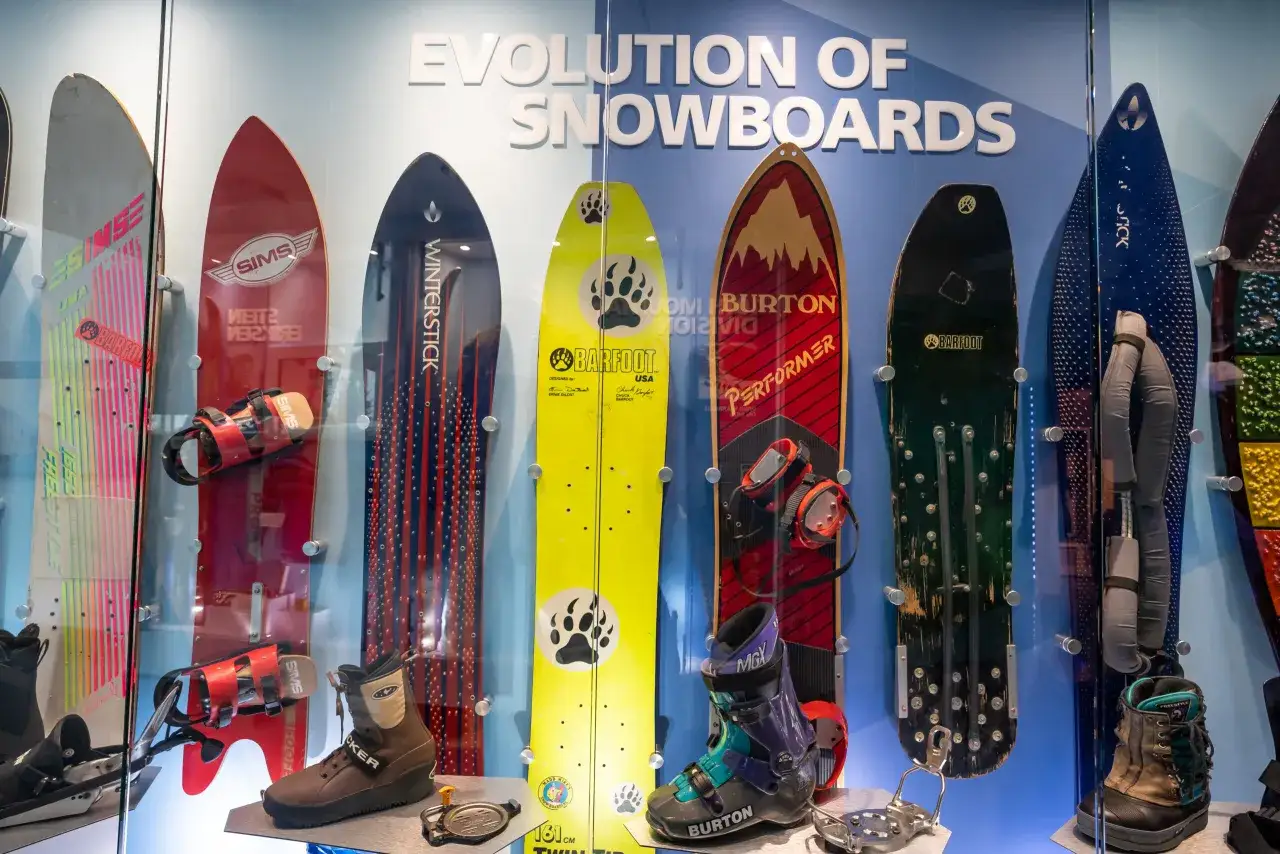Ewolucja snowboardów: od pierwszych desek, kiedy powstał snowboard, po nowoczesne modele. Wystawa prezentuje różne deski i buty snowboardowe.