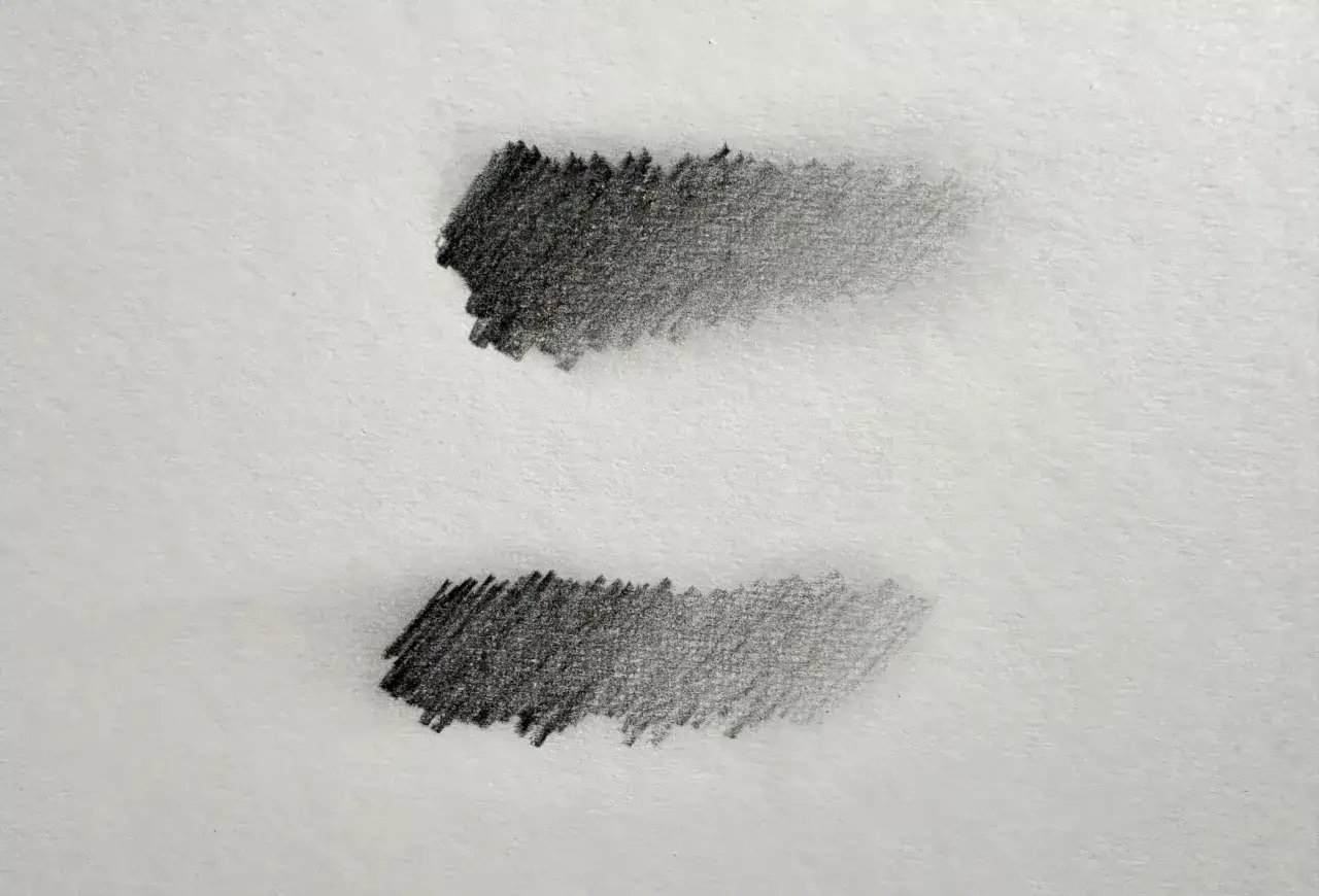 Deux d&eacute;grad&eacute;s de graphite sur papier blanc, montrant la poudre de graphite utilisation pour cr&eacute;er des ombres.