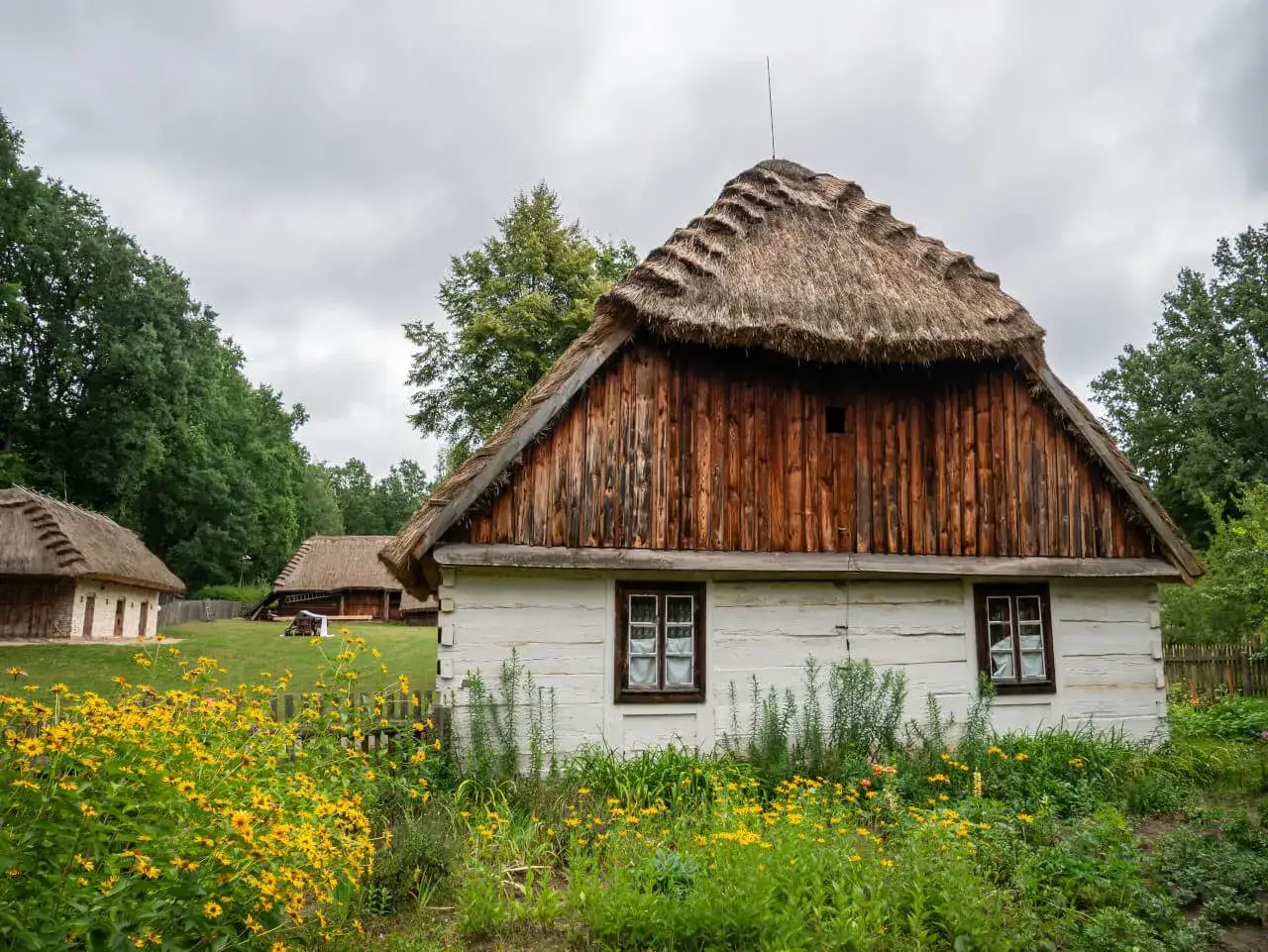 Idealne miejsce, gdzie na weekend mazowieckie. Tradycyjne chaty kryte strzechą, otoczone zielenią i polnymi kwiatami, tworzą sielski krajobraz.