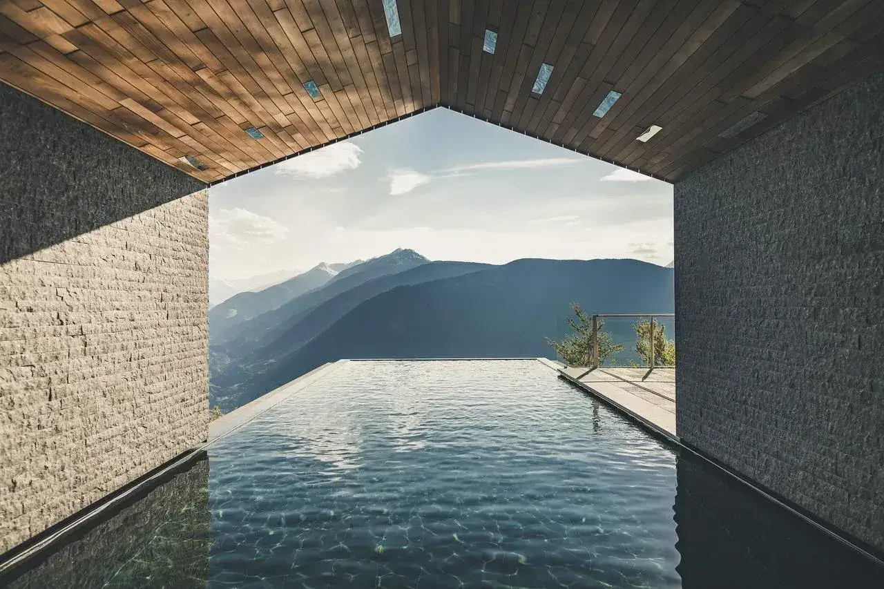 Piscina a sfioro con vista sulle Dolomiti, un'oasi di pace all'Hotel Dolomia Soraga.