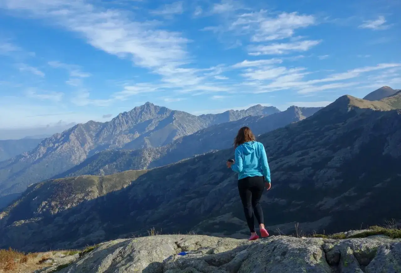 Mujer disfrutando de un paisaje montañoso espectacular durante su senderismo en Francia.