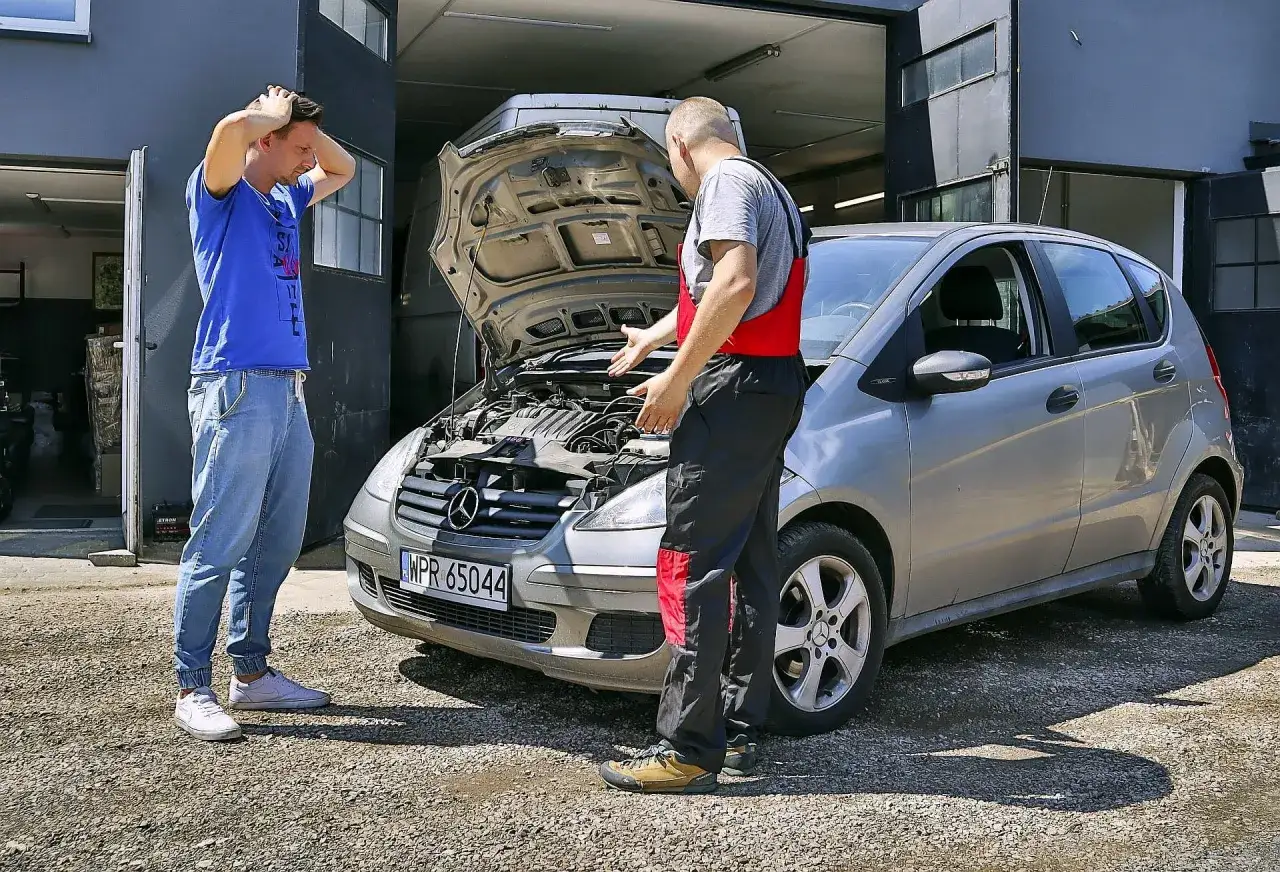 Mechanik tłumaczy klientowi, co to jest upg w samochodzie. Klient zmartwiony.