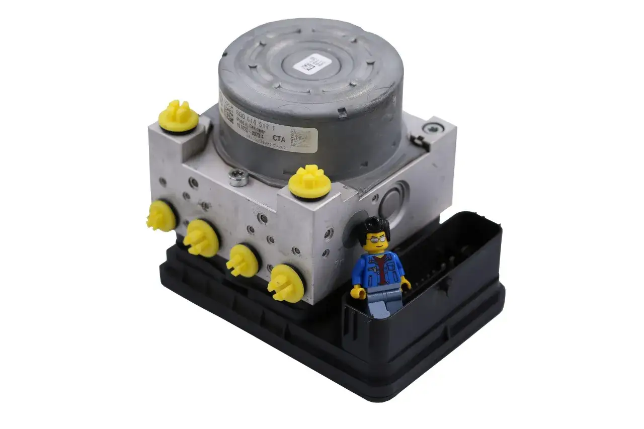 Moduł ABS z żółtymi zaślepkami i ludzikiem Lego. Po odpowietrzeniu hamulce działają jak nowe.