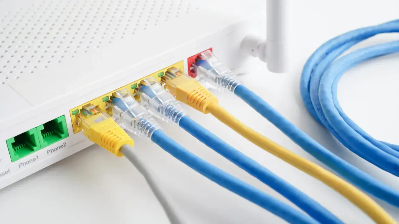 Podłączanie kabli Ethernet do routera, aby włączyć internet. Widoczne porty LAN i kable sieciowe.