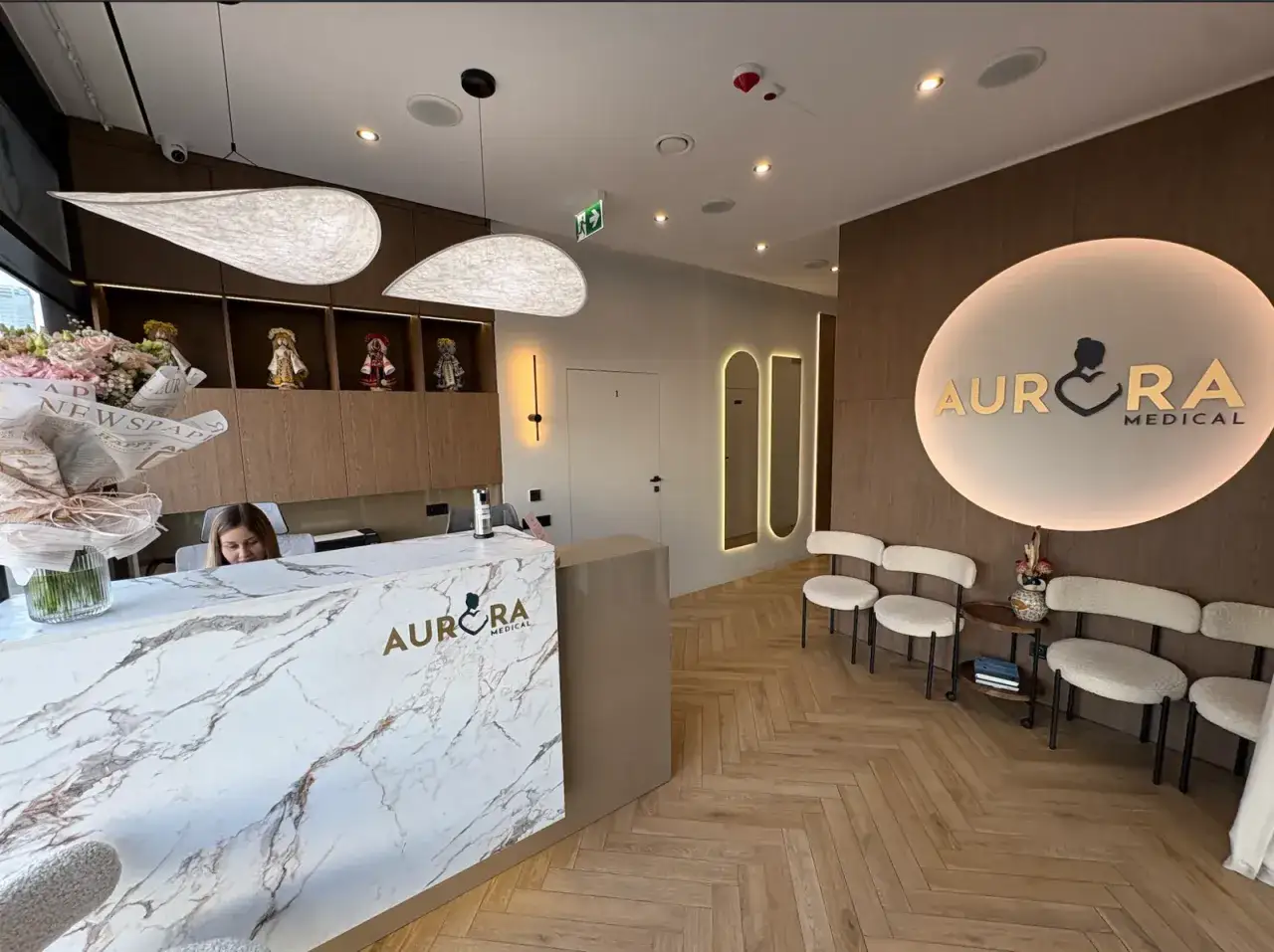 Recepcja kliniki medycznej Aurora Medical z logo, fotelem i poczekalnią.