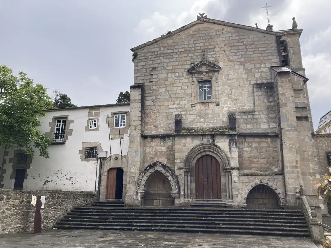 Fachada de piedra de una iglesia antigua con escalinata. Un lugar con historia, ideal para descubrir qué hacer en Viveiro.