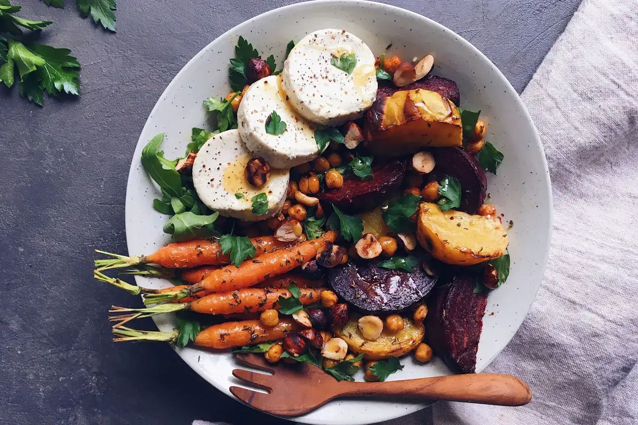 Salade colorée avec carottes rôties, betteraves, pois chiches, noisettes et rondelles de chèvre au barbecue.