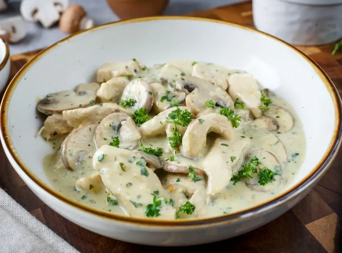Cremiges Hähnchengeschnetzeltes mit Champignons und Petersilie, ein köstliches Rezept für ein schnelles Abendessen.