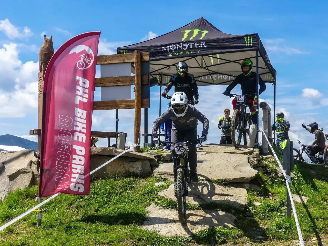 Zawodnicy MTB zjeżdżają po kamienistym torze. Czerwona flaga