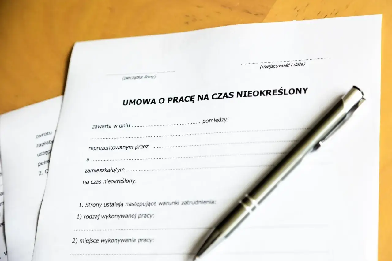 Umowa o pracę na czas nieokreślony. Dokument czeka na podpis, symbolizując rozwiązanie umowy za porozumieniem stron.