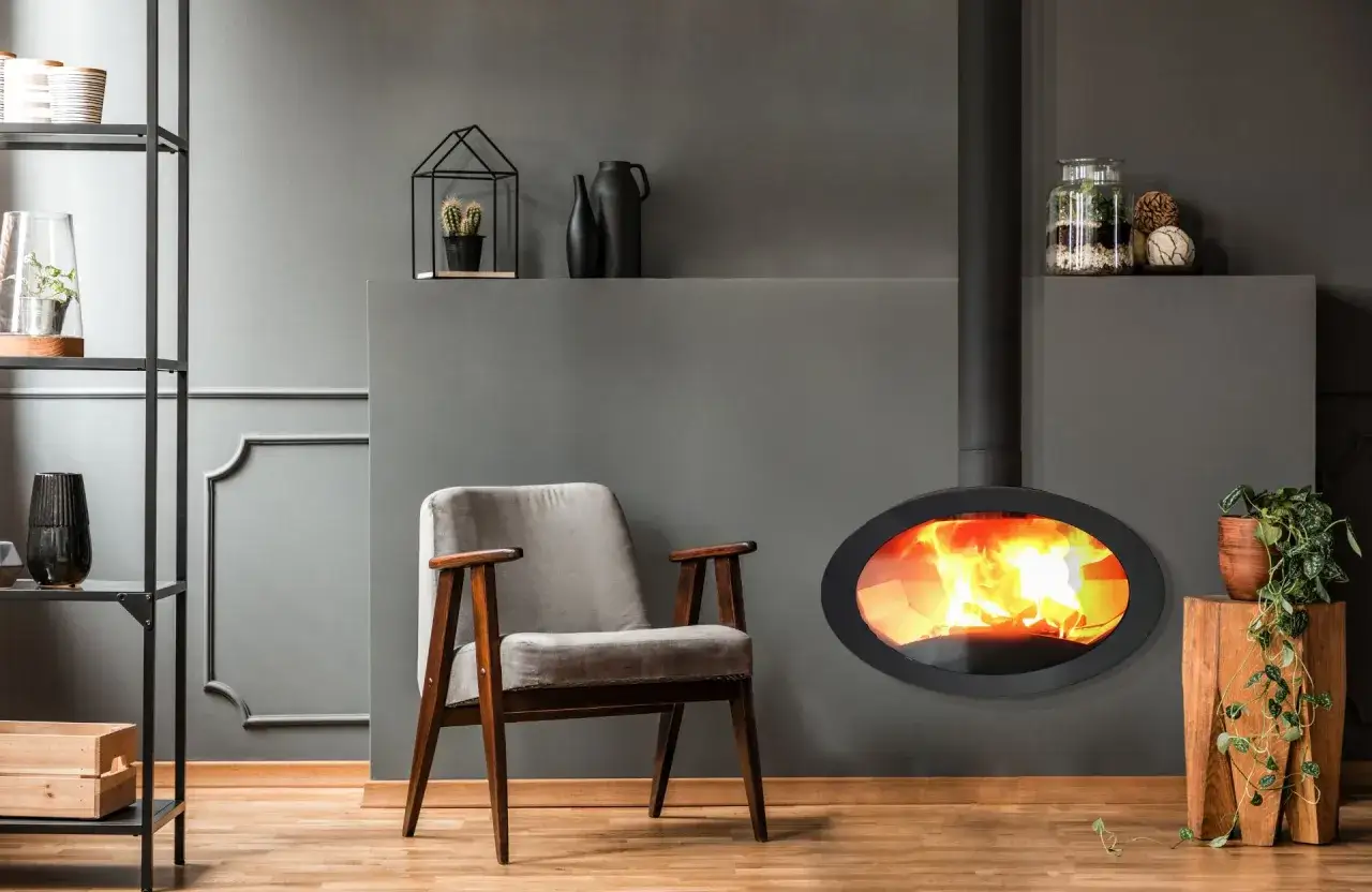 Un fauteuil confortable près d'un poêle moderne, où le **pellet ou bois** crépite joyeusement. Une ambiance chaleureuse et design.