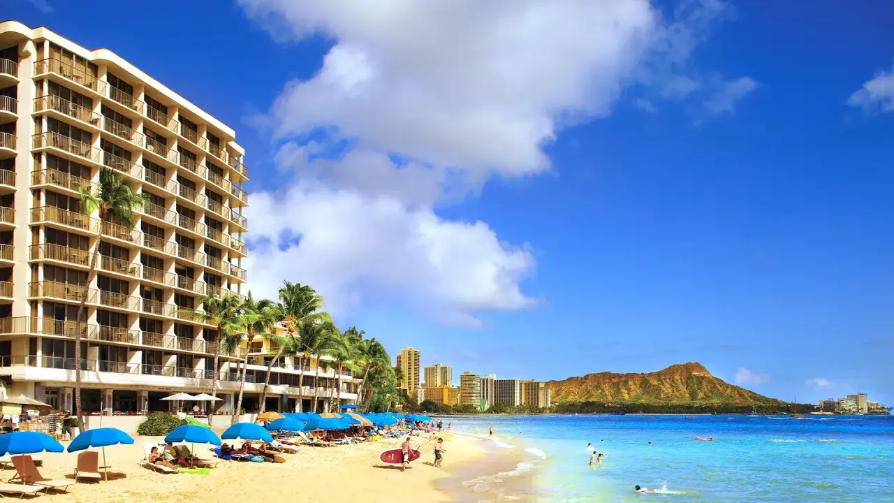 Rajskie Hawaje all inclusive: hotel przy plaży, palmy, turkusowa woda i góra Diamond Head w tle. Idealne wakacje!