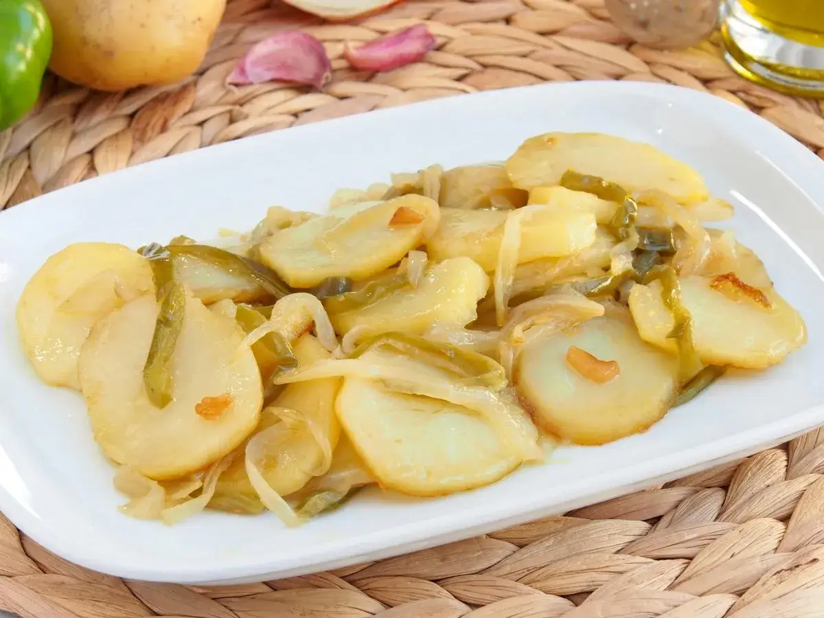 Patatas a lo pobre receta de la abuela: patatas, cebolla y pimientos verdes cocinados lentamente.