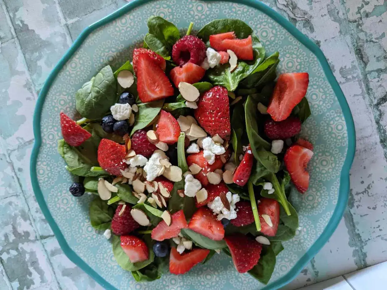 Deliciosa ensalada de espinacas con fresas, frambuesas, arándanos, queso de cabra y almendras laminadas.