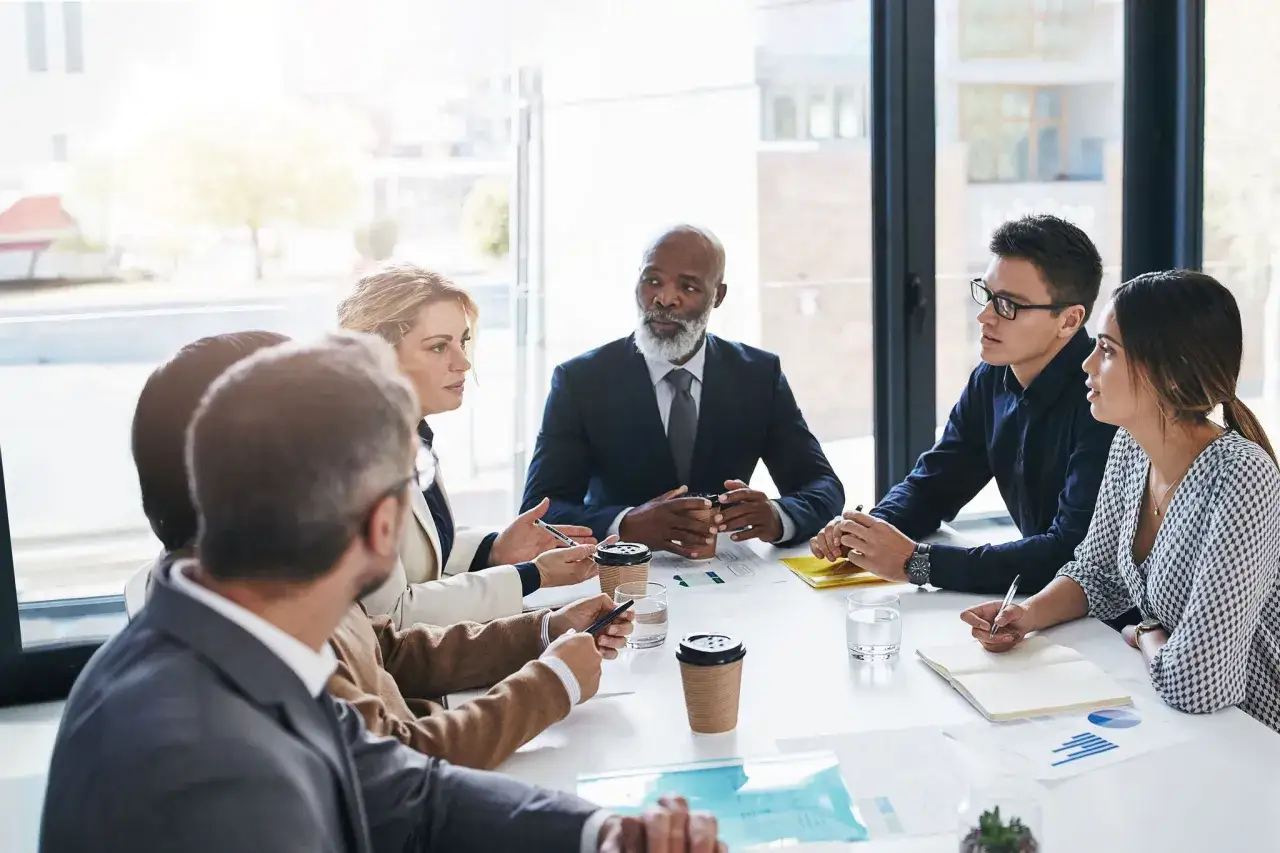 Diverse team in a meeting, discussing strategy and showing strong board engagement.