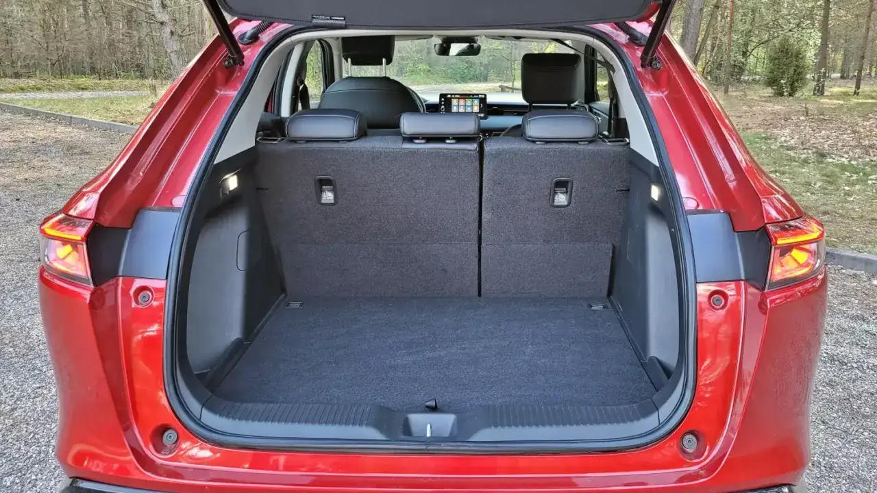 Czerwony Honda HR-V z otwartym bagażnikiem. Wnętrze jest puste, gotowe na bagaże, co pozwala ocenić honda hrv wymiary przestrzeni ładunkowej.