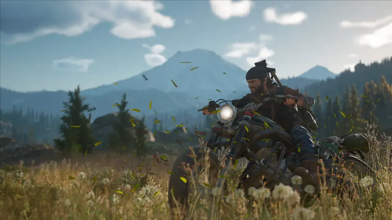 Motocyklista przemierza malownicze tereny, a wokół niego unoszą się liście. To scena z gry Days Gone 2, pełna przygód i wolności.